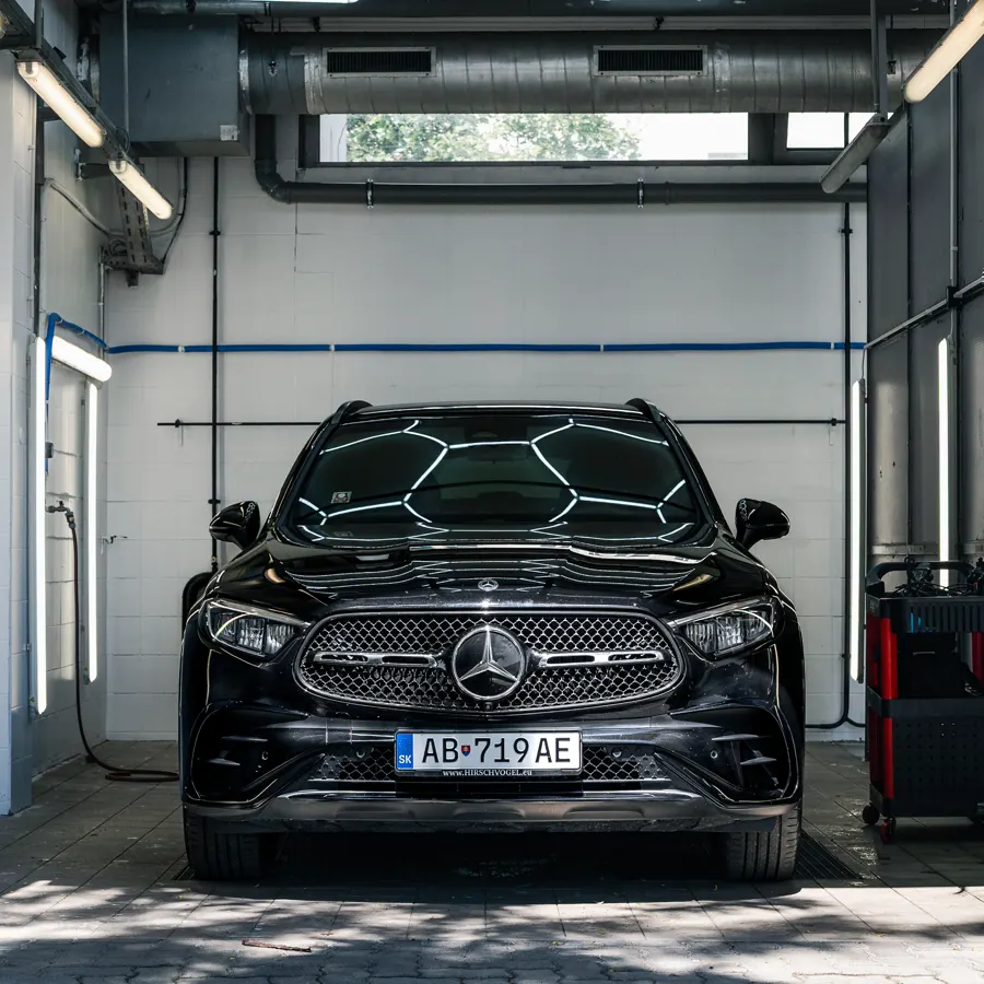 Black Mercedes GLC in the wash bay under hexagon lighting